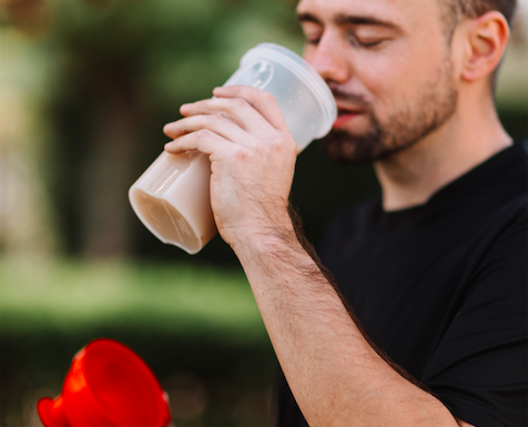 Man drinking protein shake from shaker bottle